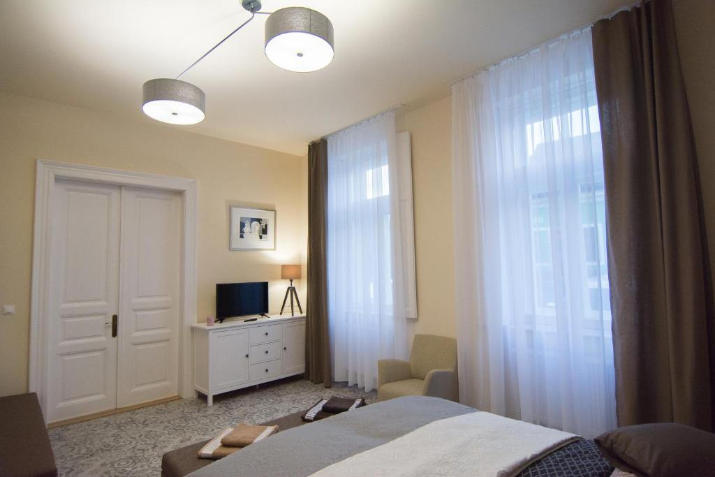 a bedroom with a bed and a window and a desk at Zora Apartman in Eger