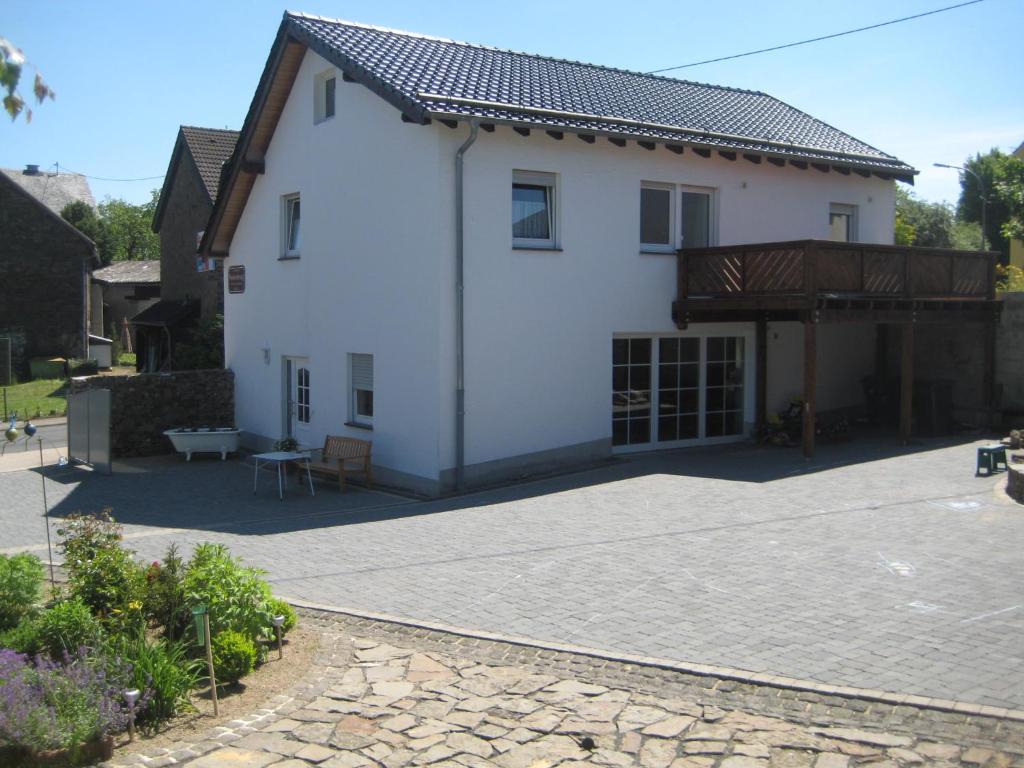 Cette maison blanche dispose d'une terrasse. dans l'établissement Ferienwohnung Hück, à Lind