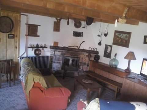 sala de estar con sofá y chimenea en Laventanadetorre, en Torre de Babia