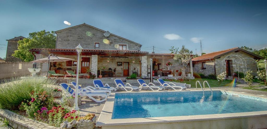 a house with a swimming pool with chairs and a house at Vila Vesna in Grožnjan