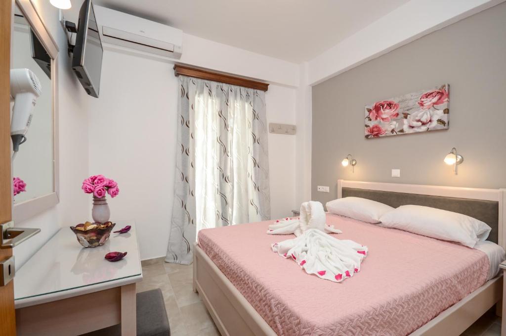 1 dormitorio con cama rosa y ventana en Margaritis Apartments 2, en Agia Anna de Naxos