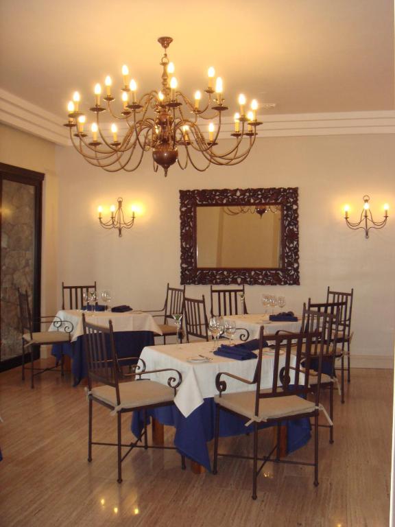 a dining room with tables and chairs and a chandelier at Villa VIK - Hotel Boutique in Arrecife