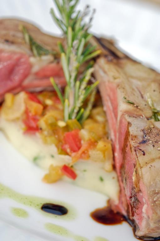 a plate of food with a piece of meat with rosemary at Villa VIK - Hotel Boutique in Arrecife