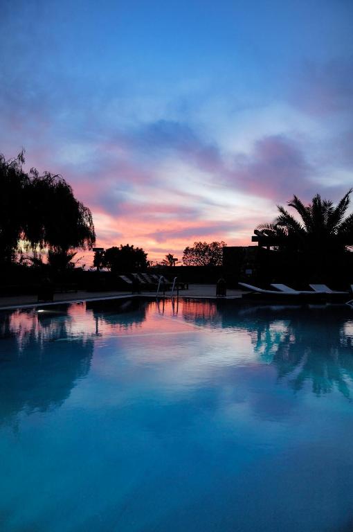a large pool of water with a sunset in the background at Villa VIK - Hotel Boutique in Arrecife