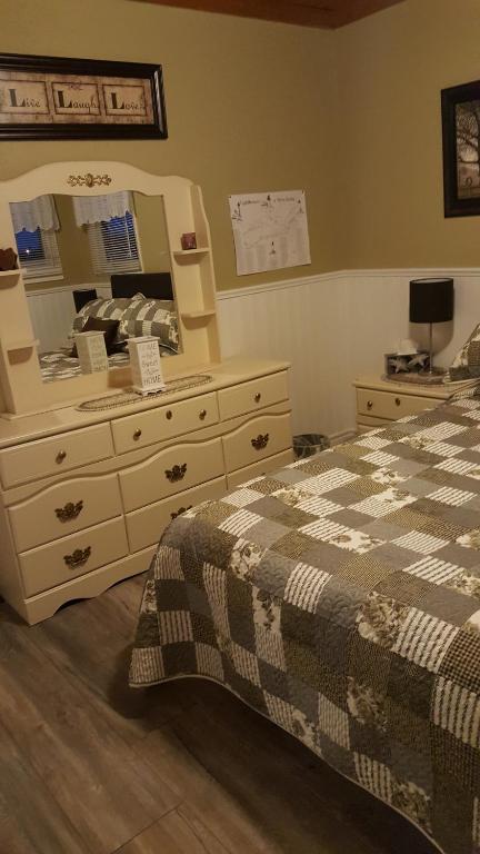 a bedroom with a bed and a dresser with a mirror at Mama`s By The Sea B&B in Clark's Harbour