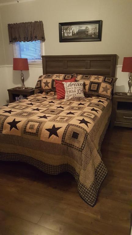 a bed with a comforter with stars on it at Mama`s By The Sea B&B in Clark's Harbour