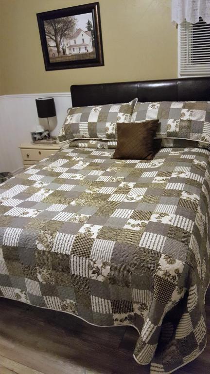 a bed with a blanket and pillows on it at Mama`s By The Sea B&B in Clark's Harbour