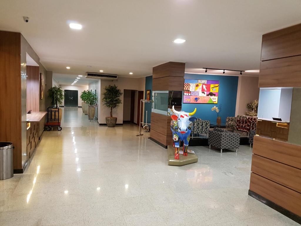 a lobby with a cow statue in the middle of it at Belém Soft Hotel in Belém