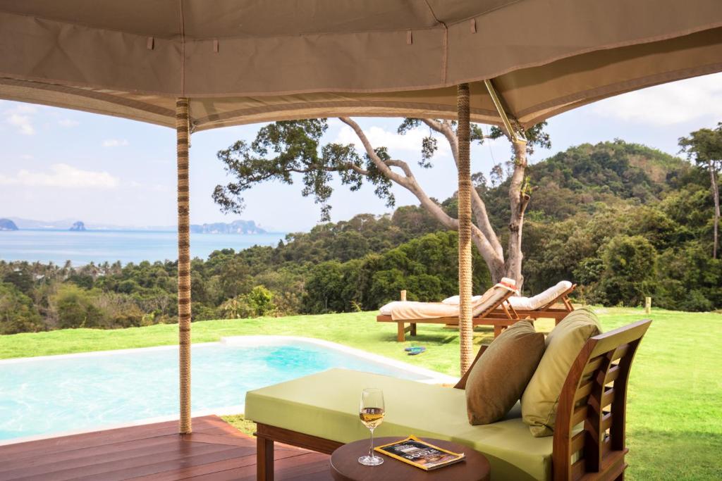 a patio with a couch and a table and a pool at Koyao Island Resort in Ko Yao Noi