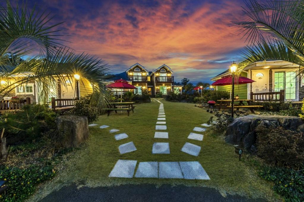 a pathway in the yard of a resort at night at Jubilee Chalet in Seogwipo