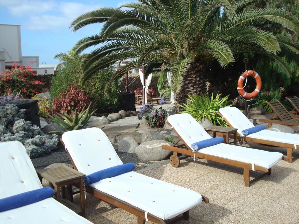 a row of chaise lounges in a garden at Villa VIK - Hotel Boutique in Arrecife