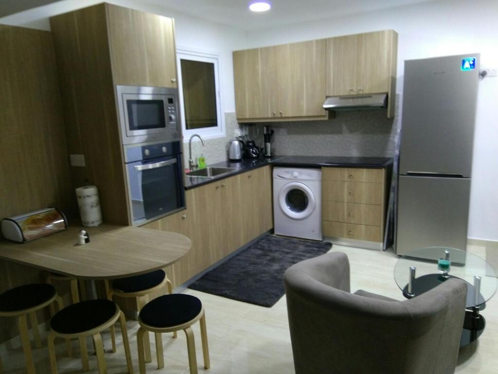 a kitchen with a table and a washer and dryer at Luxury Studio Ayia Napa Center in Ayia Napa
