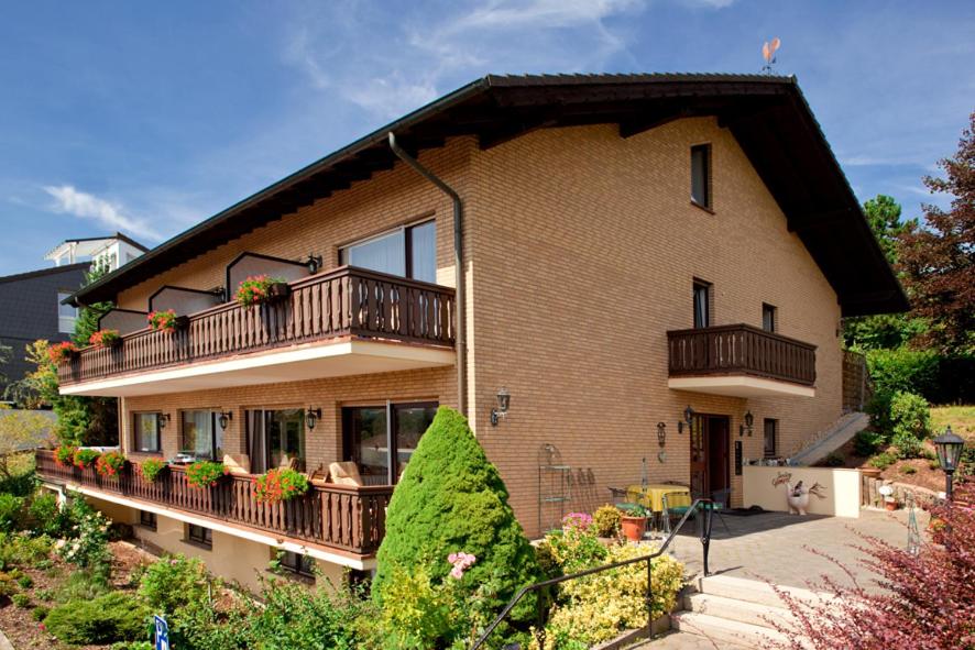 a large brick house with a balcony and plants at Pension Gimpel in Bad Wildungen