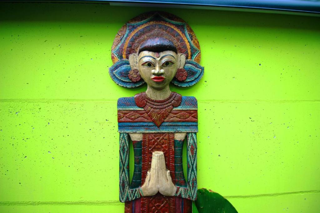 Una statua di un dio appesa a un muro di Villa Paradiso a Senggigi