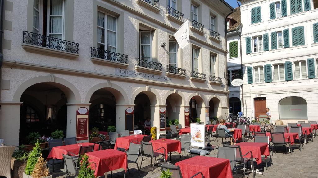 een rij tafels en stoelen voor een gebouw bij Hostellerie du XVI Siècle in Nyon