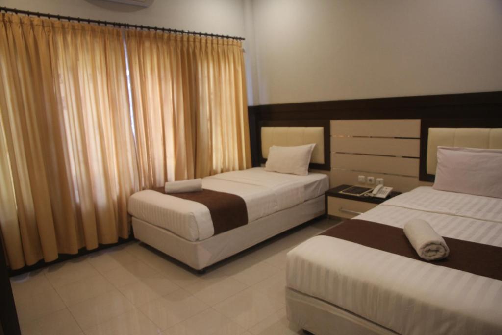 Postel nebo postele na pokoji v ubytování Puri Senggigi Hotel