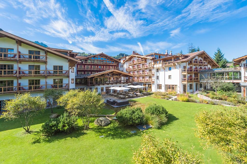 eine Apartmentanlage mit grünem Rasen und Gebäuden in der Unterkunft Kitzhof Mountain Design Resort 4 Sterne Superior in Kitzbühel