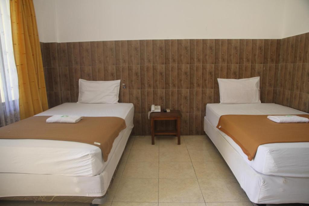 Postel nebo postele na pokoji v ubytování Puri Senggigi Hotel