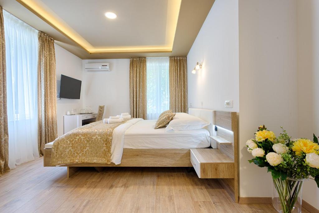 een slaapkamer met een bed en een vaas met bloemen bij Luxury Rooms Floramye in Split