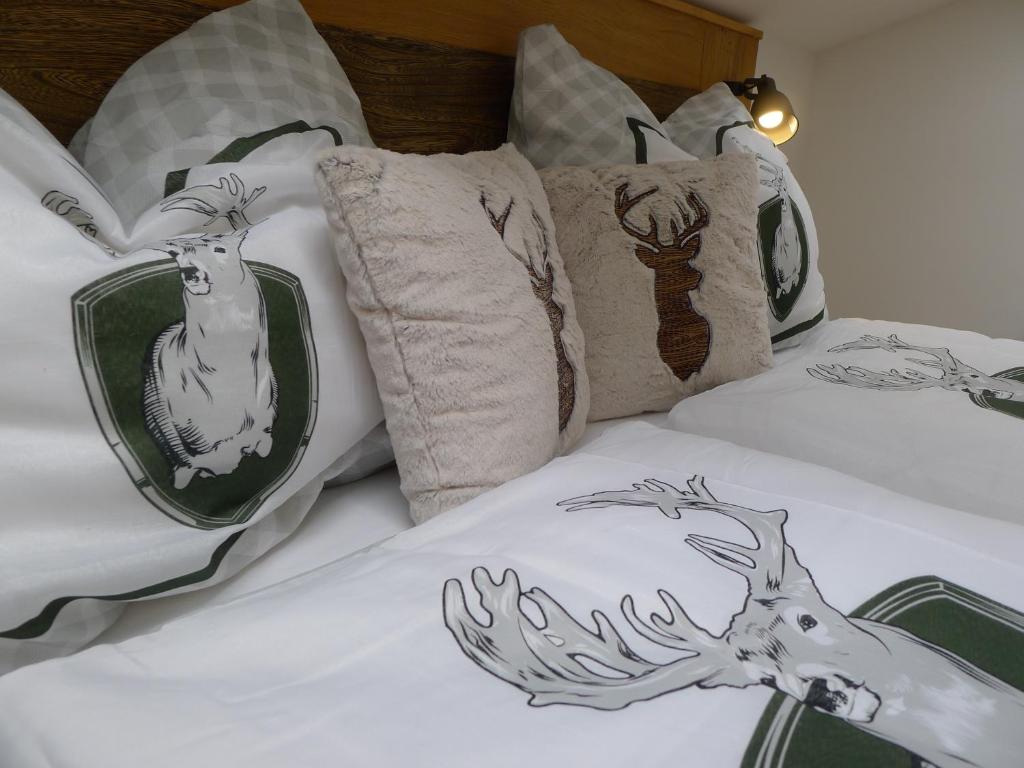 a bed with pillows with a deer on it at Alpenhaus Dachstein.Zauber in Abtenau