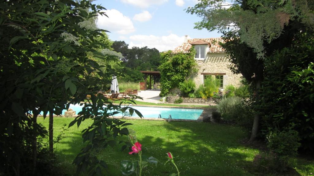 una casa y una piscina en un patio en L'âne Vert en Saint-Méard-de-Gurçon