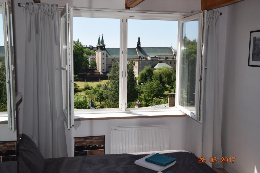 a room with a window with a view of a castle at Yellow Peaked Shoe Apartment in Krakow