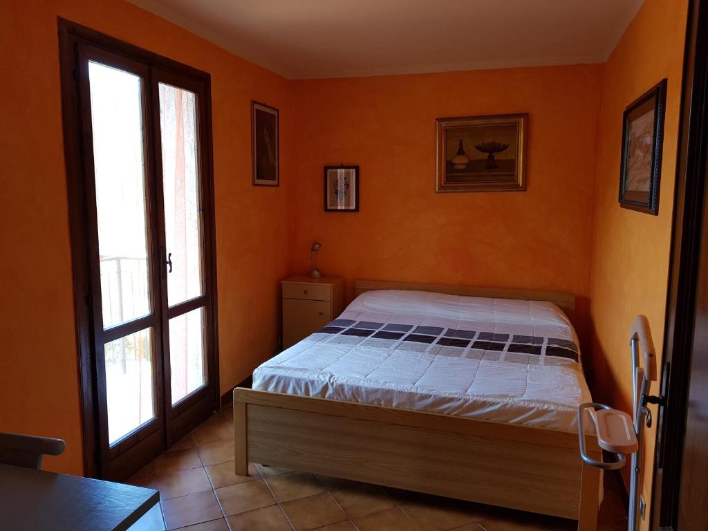 Pieve di Teco的住宿－Green House，一间设有床铺的卧室,位于一个拥有橙色墙壁的房间