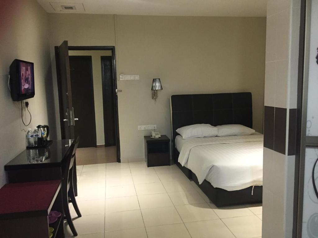 Postel nebo postele na pokoji v ubytování Ayer Hitam Hotel