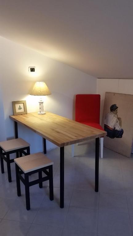 トッレ・ファロにあるCariddi Atticの木製テーブル(ランプ付)と赤い椅子