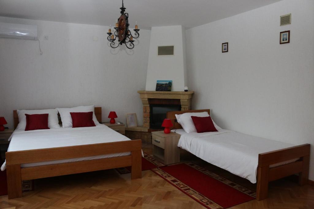 a bedroom with two beds and a fireplace at House Bogović in Karlovac