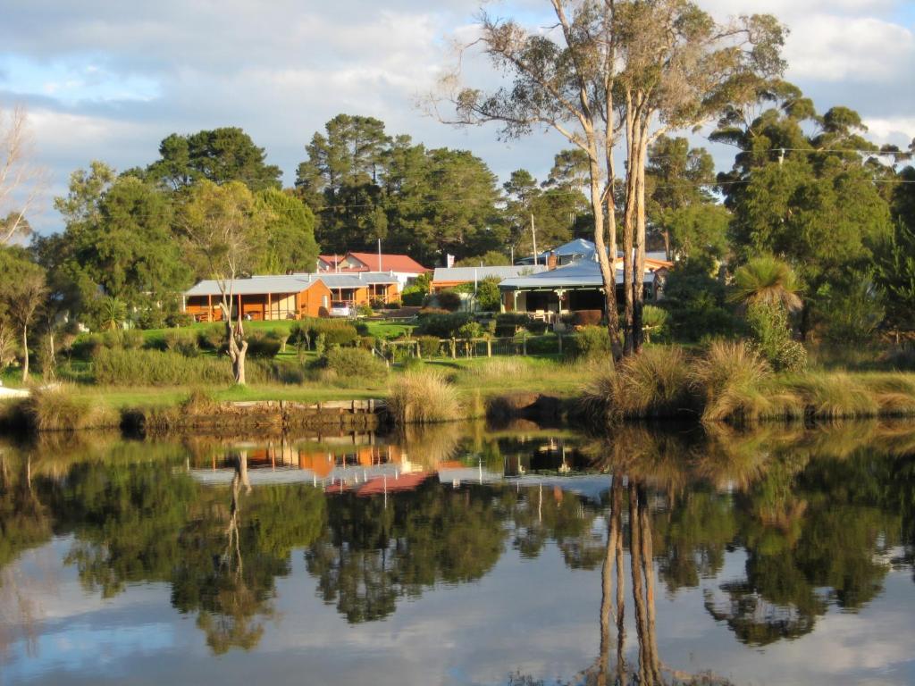 a house reflected in the water of a lake at Nornalup Riverside Chalets in Nornalup