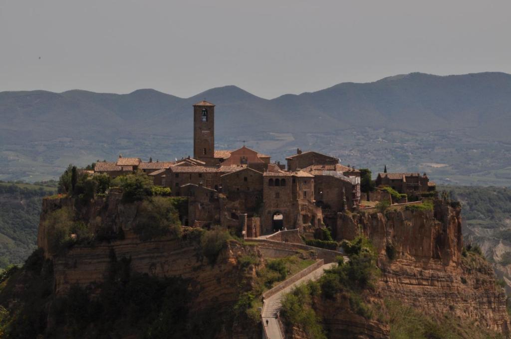 a village on top of a mountain with a clock tower at Butterfly in Bagnoregio