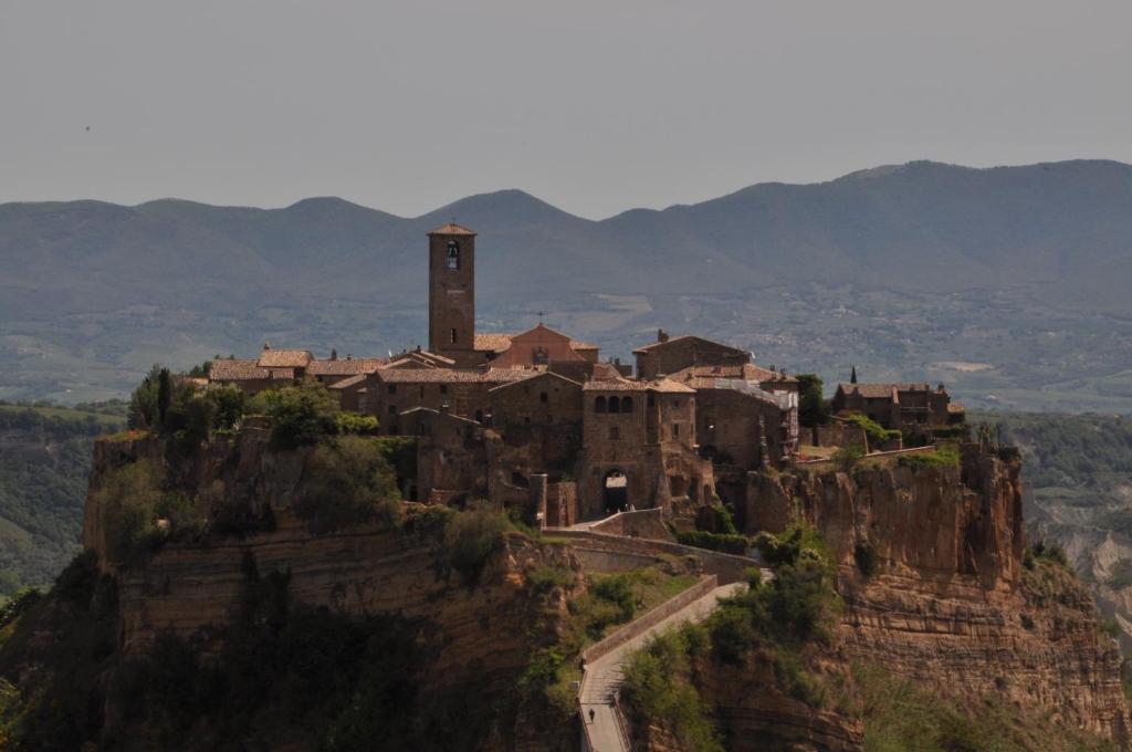 un village au sommet d'une montagne avec une tour d'horloge dans l'établissement Butterfly, à Bagnoregio