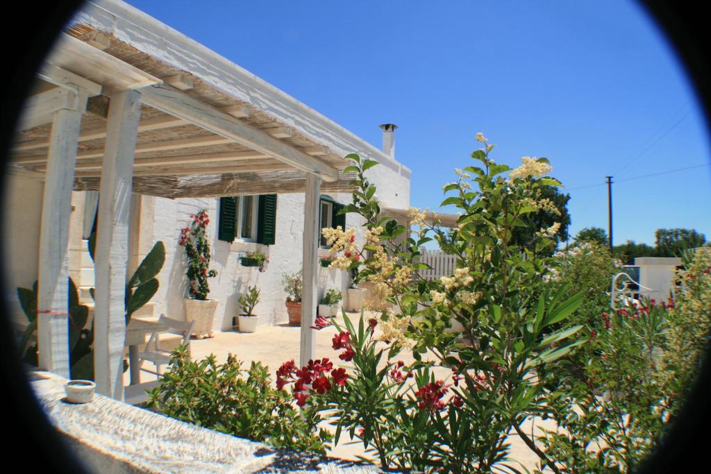 une maison avec un jardin agrémenté de fleurs et de plantes dans l'établissement Casolare Capitolo, à Cisternino