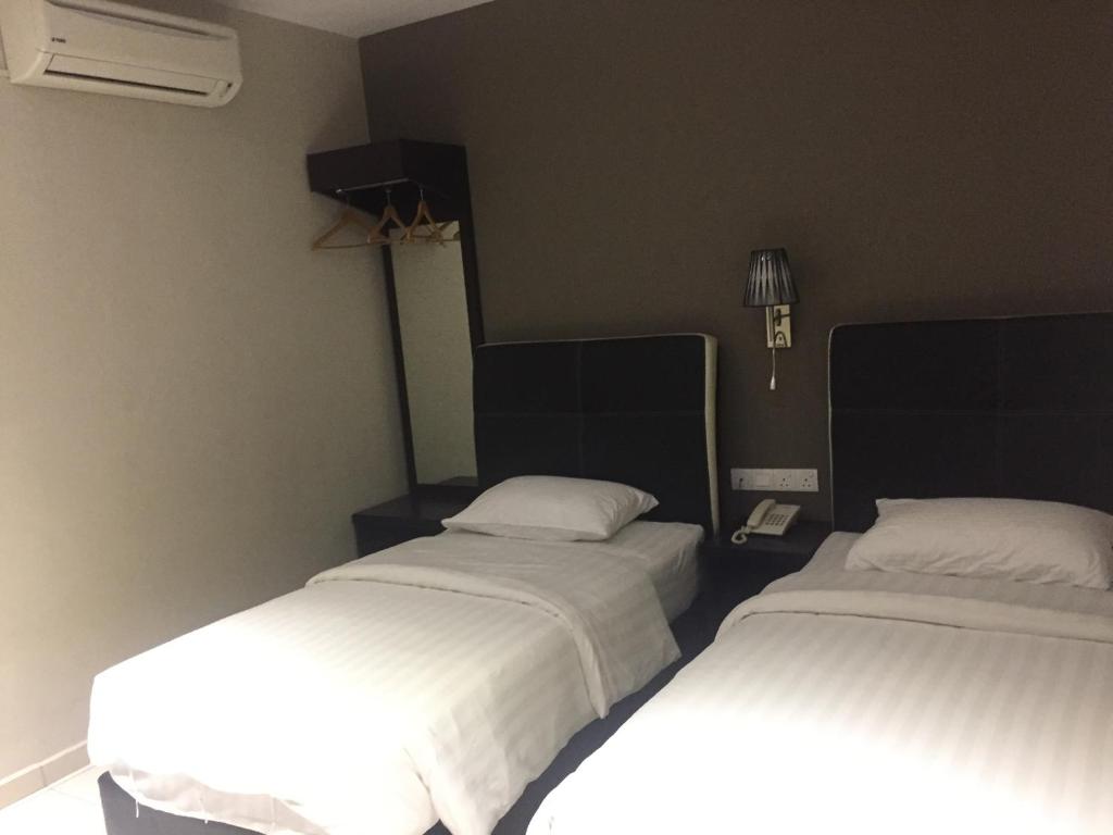 Postel nebo postele na pokoji v ubytování Ayer Hitam Hotel
