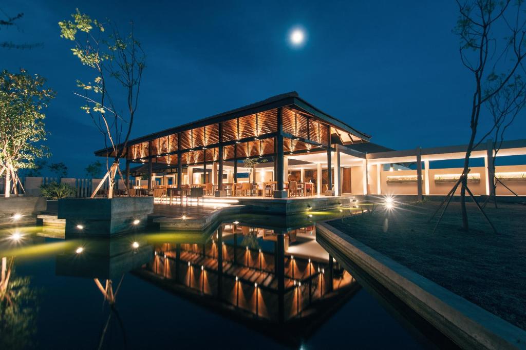 a building with a pool in front of it at night at The Palmyrah House in Mannar