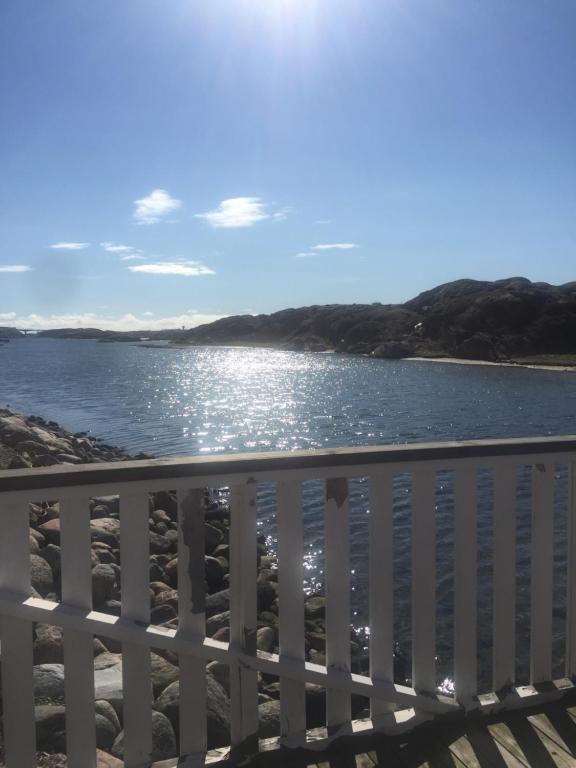 a view of the ocean from a white fence at Seaview Cottage Solvik - Kungshamn in Kungshamn