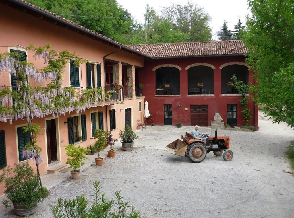 un homme à bord d'un tracteur devant un bâtiment dans l'établissement Cascina Sant'Eufemia, à Sinio