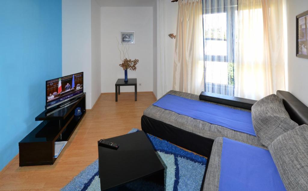 a living room with a couch and a television at Meri Apartment in Rijeka