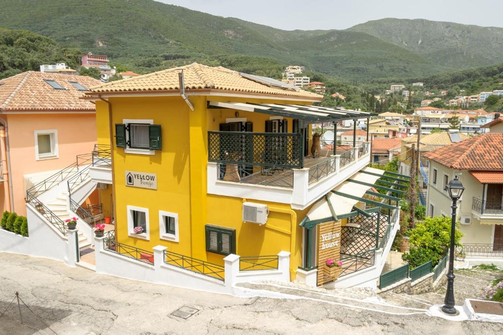 een geel huis met balkons in een stad bij Yellow house in Parga
