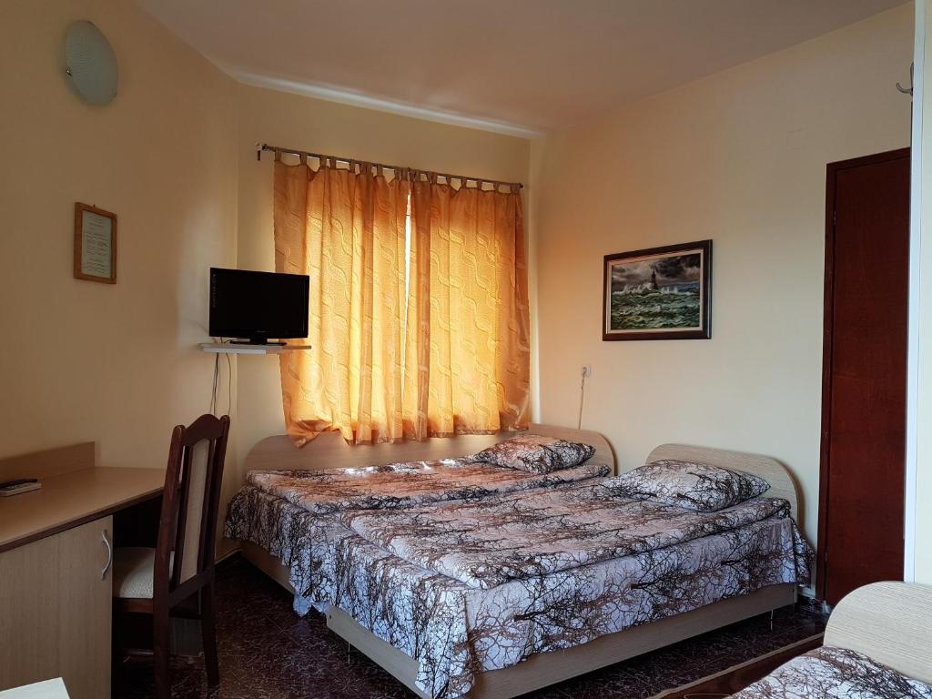 a bedroom with two beds and a window at Hotel Fantasy in Lyubimets
