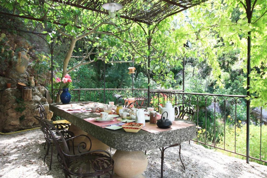 una mesa en un patio con una valla y una mesa en Le Moulin en Provence, en Saint-Antonin-sur-Bayons