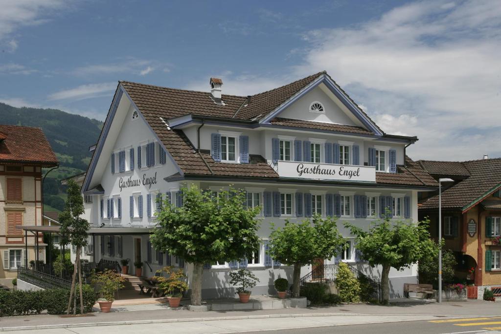 un gran edificio blanco con techo de gambrel en Gasthaus Engel, en Sachseln