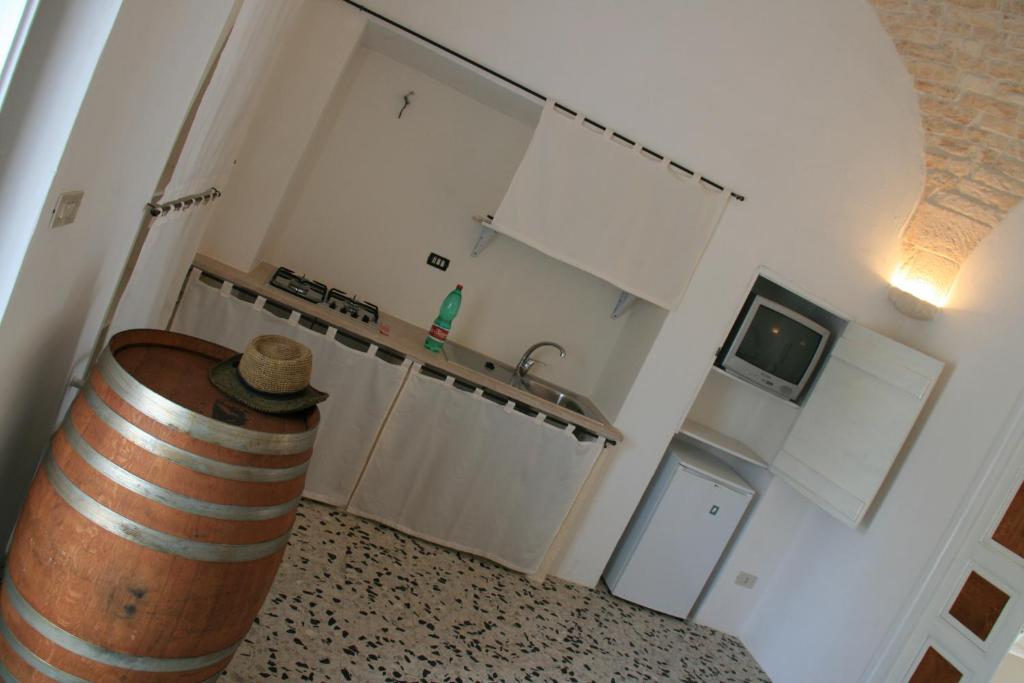 a kitchen with a barrel in the corner of a room at Casolare Capitolo in Cisternino