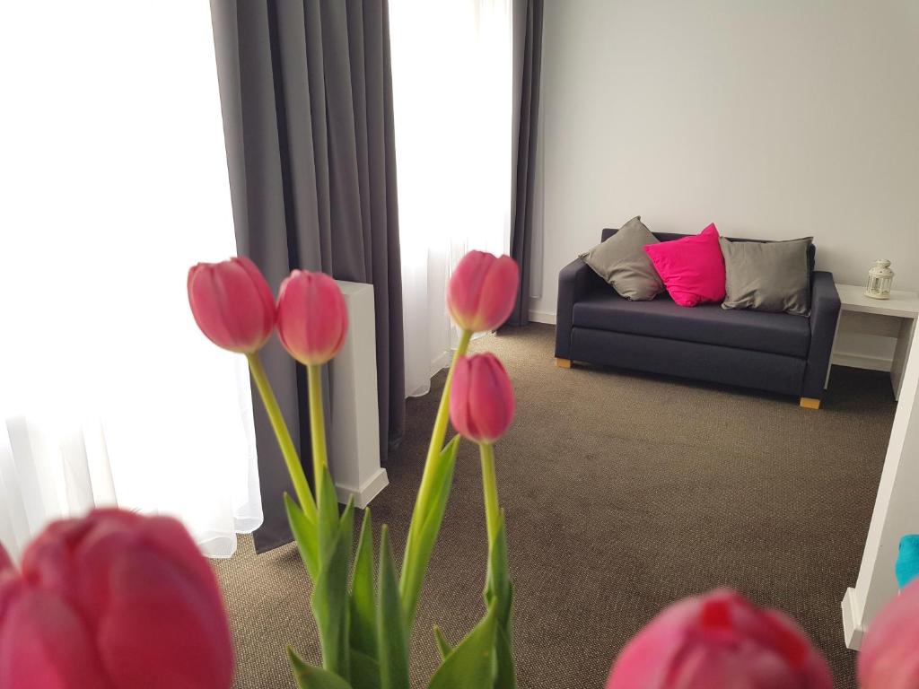 a living room with red tulips in front of a couch at Villa Julia in Międzyzdroje