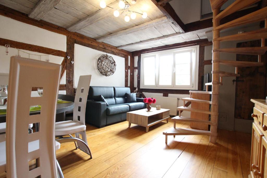 un salon avec un canapé bleu et une chambre avec une table dans l'établissement Gîte Par ci, Par là, à Turckheim