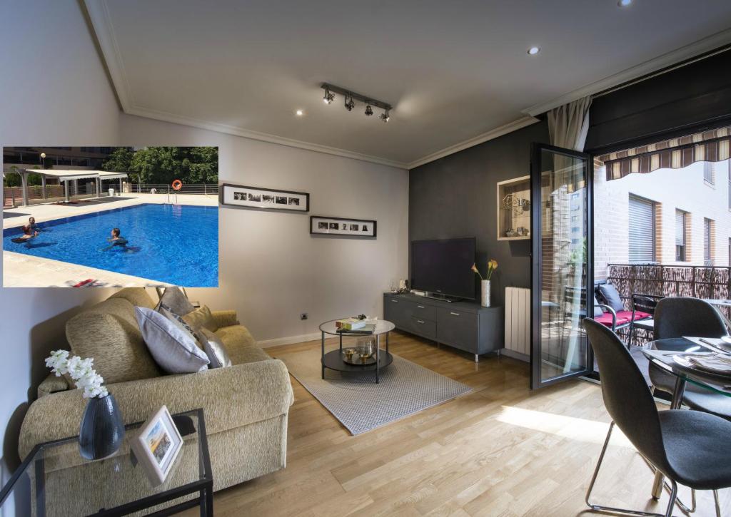 salon z kanapą i basenem w obiekcie Premium luxury city center apartment w Madrycie
