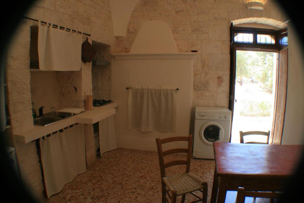 a kitchen with a sink and a table and chairs at Casolare Capitolo in Cisternino