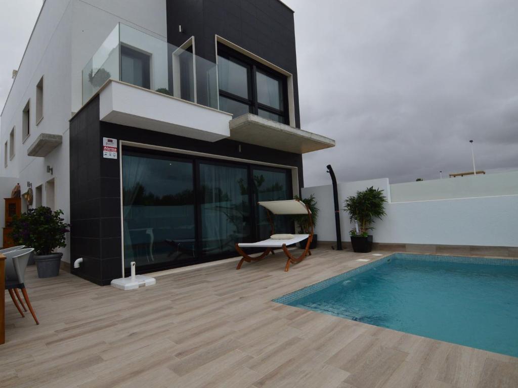 a house with a swimming pool next to a building at Belvilla by OYO Casa del Ananas in San Pedro del Pinatar