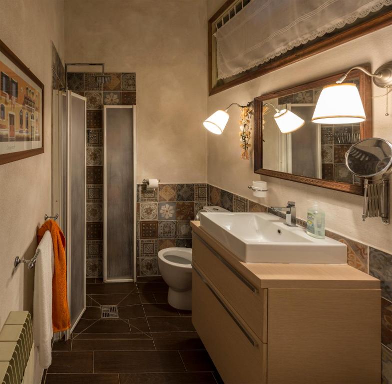 een badkamer met een wastafel en een toilet bij La Casa del Viaggiatore in Castiglion Fiorentino